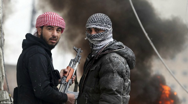 Dos combatientes sirios ofrecen un momento fotográfico en medio del combate.
