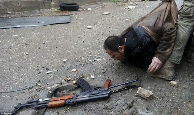 Un AK47 rebelde es abandonado mientras su dueño es arrastrado fuera del peligro.