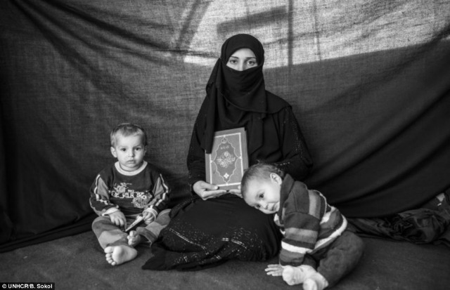 Para proteger a sus hijos, esta mujer carga una copia del Libro Sagrado del Islam.