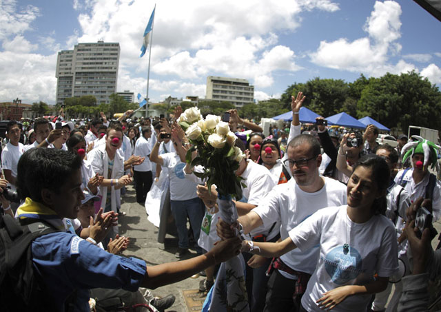 People pass bouquet of roses along human chain on streets of downtown Guatemala city to commemorate International Day of Peace in Guatemala City