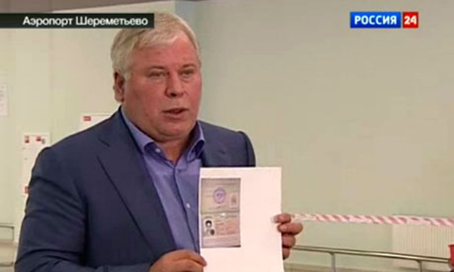 Anatoly Kucherena, Edward Snowden's lawyer, shows a copy of a temporary document allowing