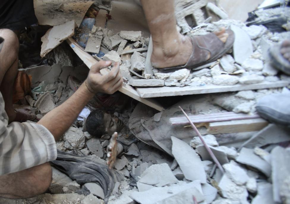 Palestinians rescue Mahmoud al-Ghol from under the rubble of a house in Rafah in the southern Gaza Strip