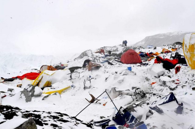 TOPSHOTS In this photograph taken on April 25, 2015, people look on at the devastation after an avalanche triggered by an earthquake flattened parts of Everest Base Camp.   Rescuers in Nepal are searching frantically for survivors of a huge quake on April 25, that killed nearly 2,000, digging through rubble in the devastated capital Kathmandu and airlifting victims of an avalanche at Everest base camp.   AFP PHOTO/Roberto SCHMIDTROBERTO SCHMIDT/AFP/Getty Images