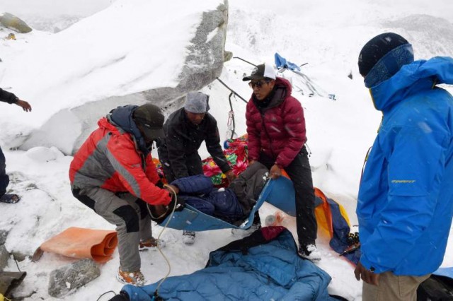 In this photograph taken on April 25, 2015, rescuers help a porter onto a makeshift stretcher after he was injured by an avalanche caused by an earthquake, before being evacuated to a medical tent in another area of Everest Base Camp.   Rescuers in Nepal are searching frantically for survivors of a huge quake on April 25, that killed nearly 2,000, digging through rubble in the devastated capital Kathmandu and airlifting victims of an avalanche at Everest base camp.   AFP PHOTO/Roberto SCHMIDTROBERTO SCHMIDT/AFP/Getty Images
