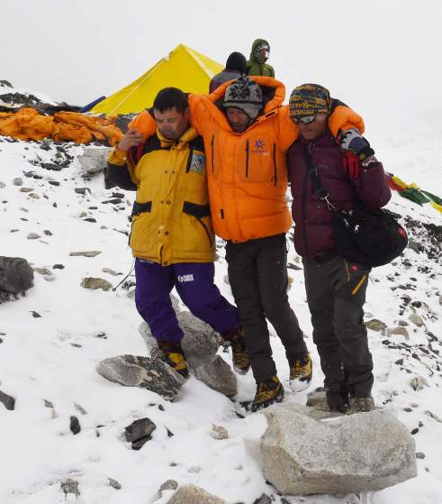 In this photograph taken on April 25, 2015, rescuers assist an injured person after an earthquake triggered by an avalanche flattened parts of Everest Base Camp.   Rescuers in Nepal are searching frantically for survivors of a huge quake on April 25, that killed nearly 2,000, digging through rubble in the devastated capital Kathmandu and airlifting victims of an avalanche at Everest base camp.   AFP PHOTO/Roberto SCHMIDTROBERTO SCHMIDT/AFP/Getty Images