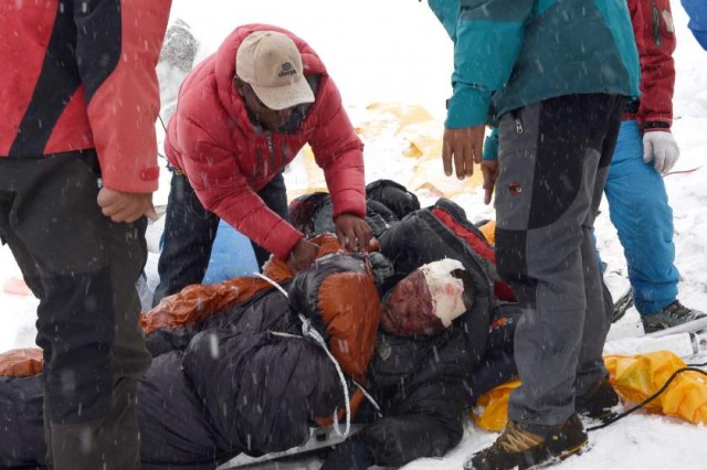In this photograph taken on April 25, 2015, rescuers tend to a sherpa injured by an avalanche that flattened parts of Everest Base Camp.   Rescuers in Nepal are searching frantically for survivors of a huge quake on April 25, that killed nearly 2,000, digging through rubble in the devastated capital Kathmandu and airlifting victims of an avalanche at Everest base camp.   AFP PHOTO/Roberto SCHMIDTROBERTO SCHMIDT/AFP/Getty Images
