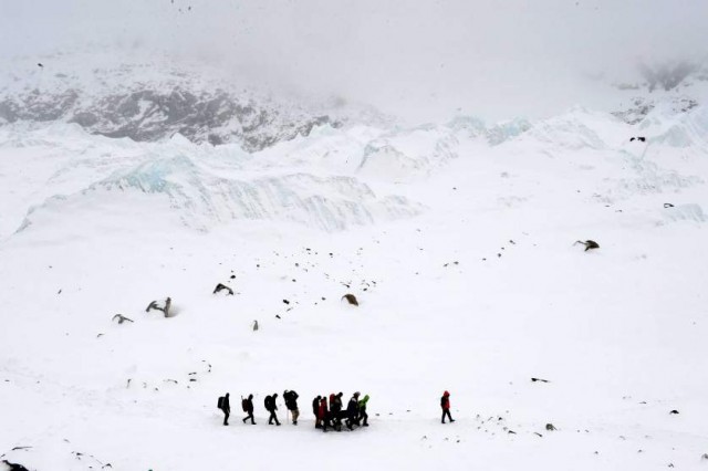 In this photograph taken on April 25, 2015, rescuers carry a sherpa injured by an avalanche that flattened parts of Everest Base Camp.   Rescuers in Nepal are searching frantically for survivors of a huge quake on April 25, that killed nearly 2,000, digging through rubble in the devastated capital Kathmandu and airlifting victims of an avalanche at Everest base camp.   AFP PHOTO/Roberto SCHMIDTROBERTO SCHMIDT/AFP/Getty Images