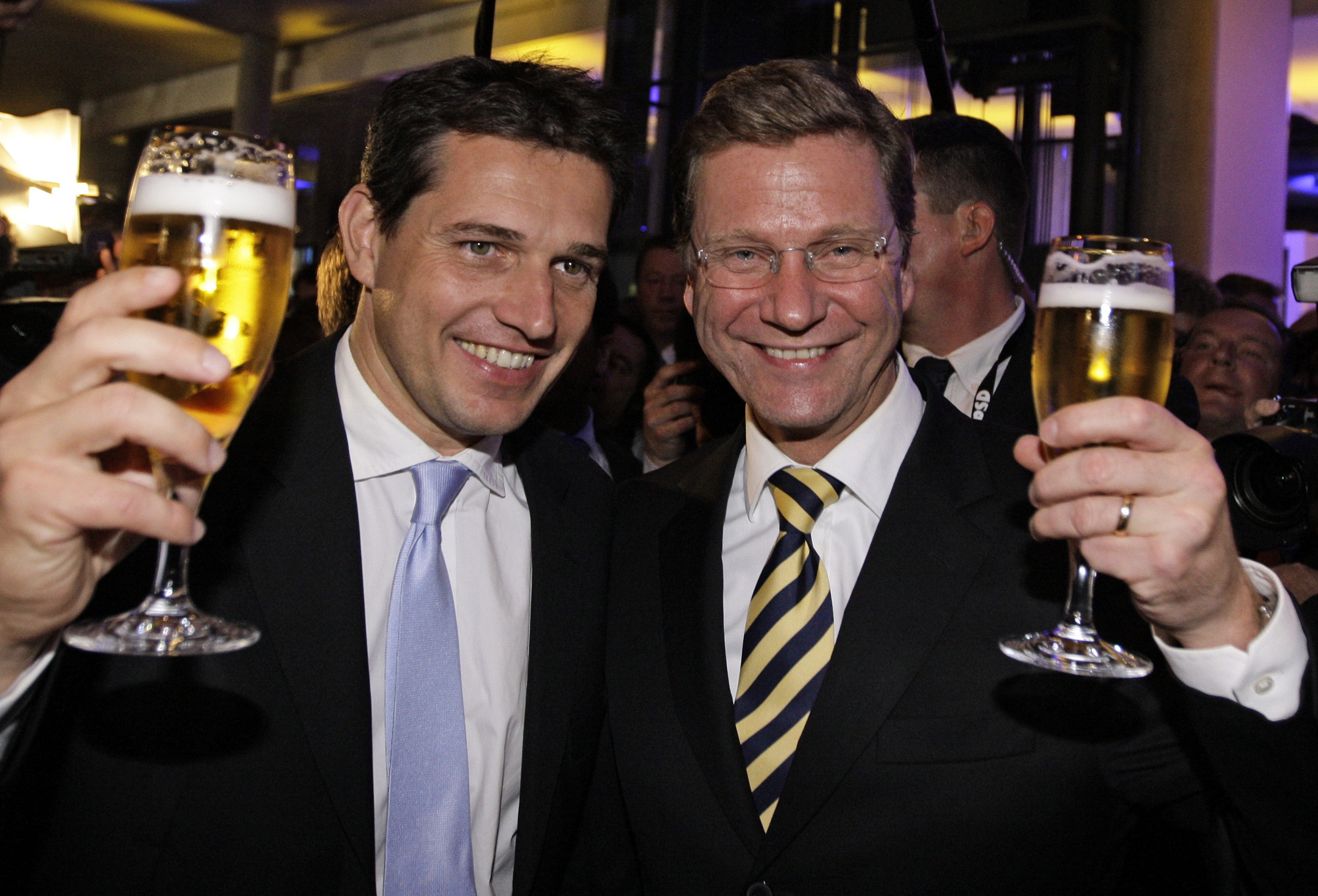 Guido Westerwelle (R), leader of the pro-business Free Democratic Party (FDP) and his partner Michael Mronz celebrate at the FDP venue after the German general election (Bundestagswahl) in Berlin September 27, 2009. German voters gave Chancellor Angela Merkel a second term in an election on Sunday and a mandate to form a new government with the business-friendly Free Democrats (FDP) that is expected to cut taxes to boost growth.  REUTERS/Thomas Bohlen  (GERMANY)