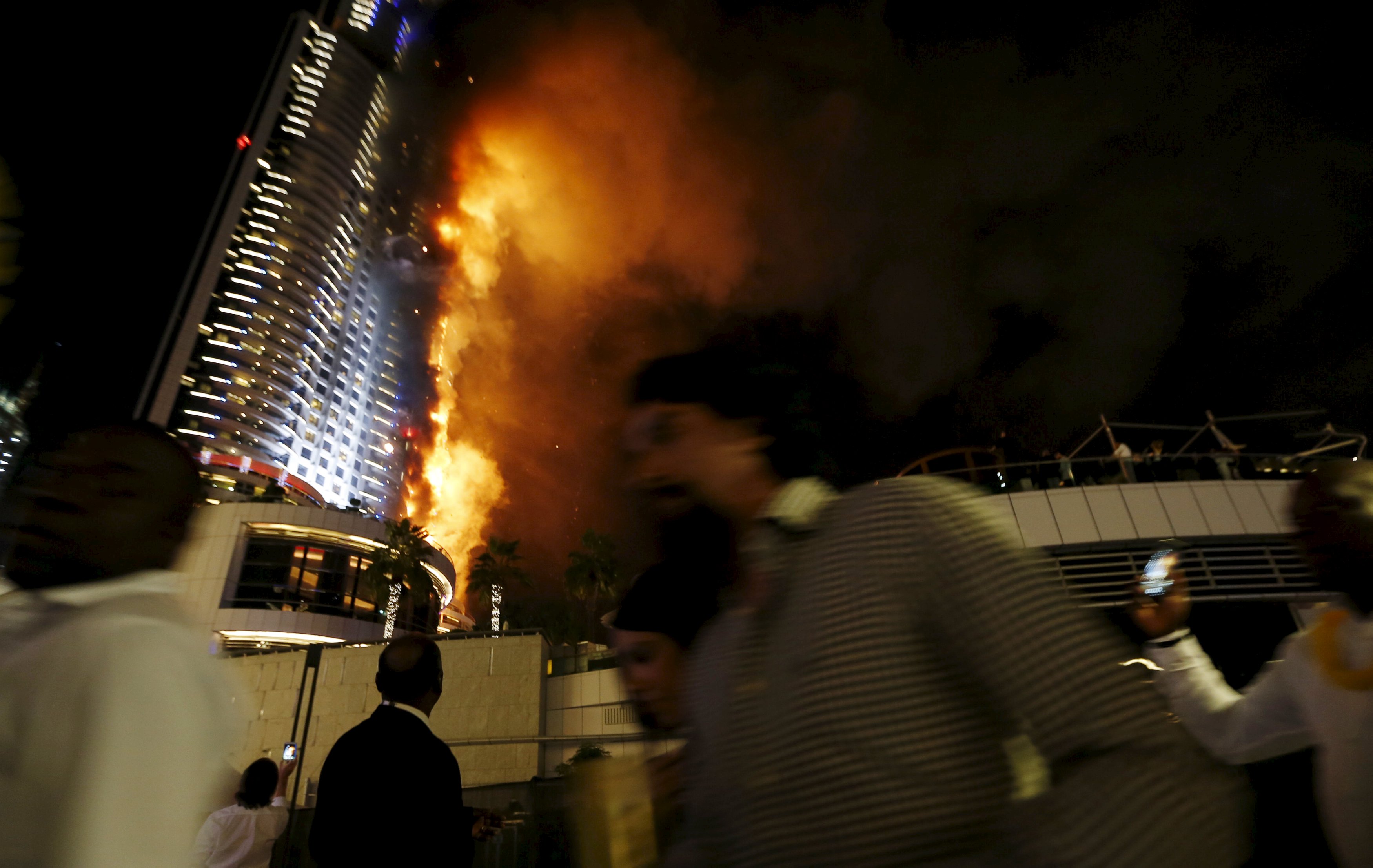 People run away as a fire engulfs The Address Hotel in downtown Dubai in the United Arab Emirates December 31, 2015. REUTERS/Ahmed Jadallah