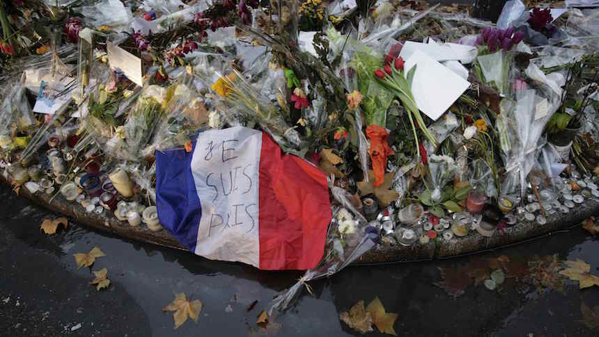 A French flag with the message "I am Paris" is seen among candles and flowers left by passers-by at an informal memorial in front of the"Casa Nostra" pizzeria, one of the sites of the Paris attacks