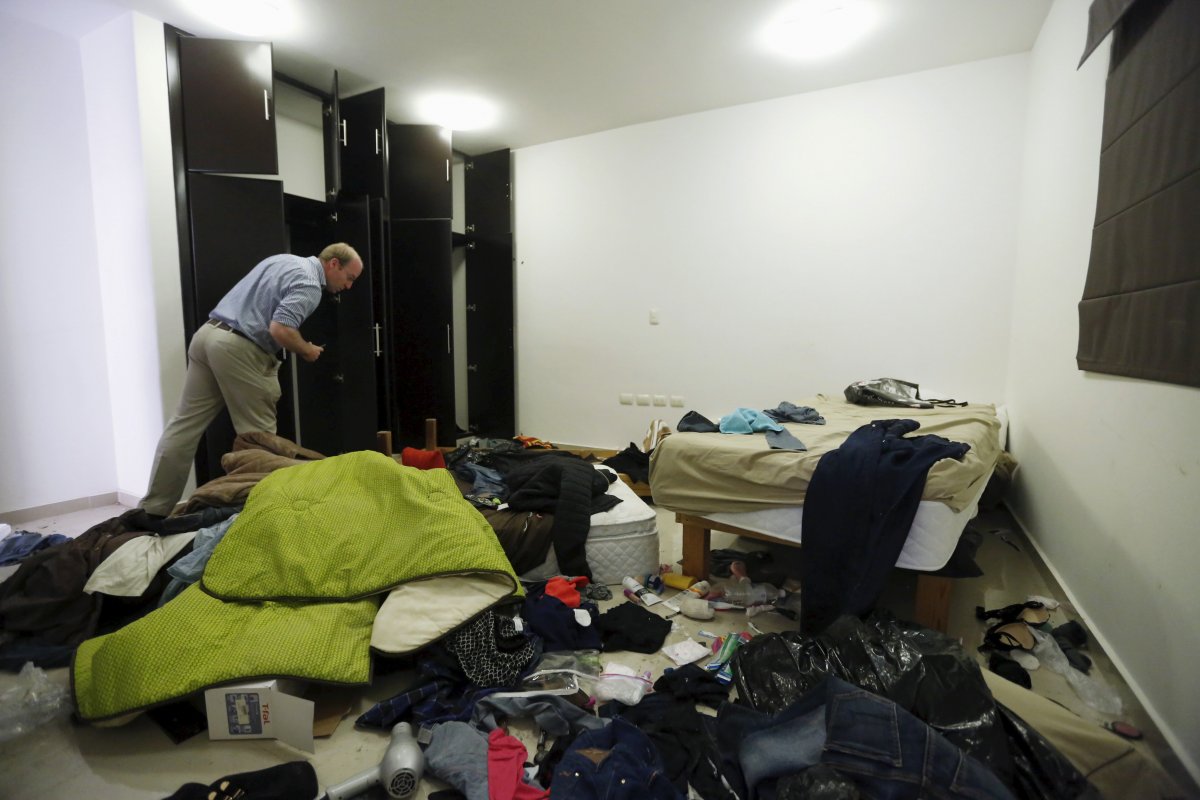 a-journalist-looks-at-belongings-scattered-across-one-of-the-hideouts-bedrooms