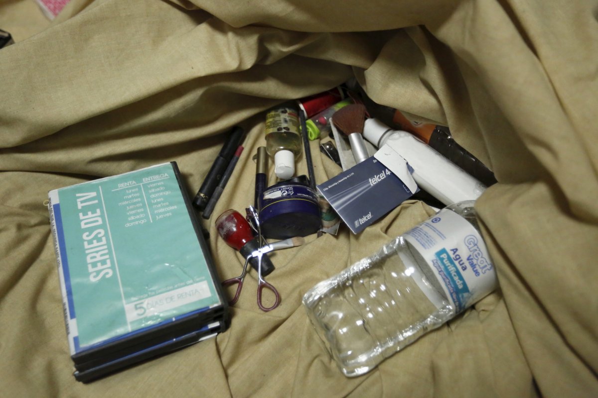 nail-polish-makeup-body-lotion-a-water-bottle-and-dvds-are-seen-on-sheets-of-a-bed-inside-the-safe-house