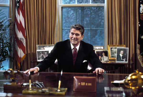 President Ronald Reagan at his desk in the Oval Office.