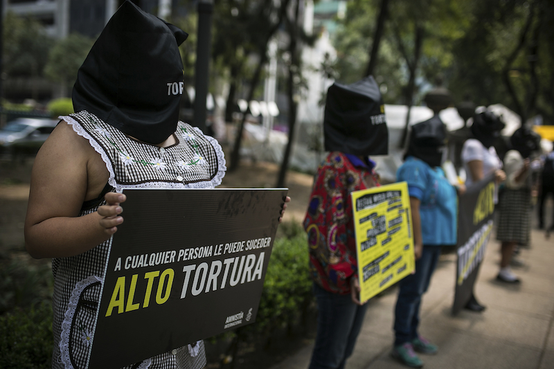 MEXICO CITY, MEXICO - JUNE 26: Women of Amnesty International, hold a banner during the protest as part of the UN's International Day in Support of Victims of Torture at Attorney General of Mexico on June 26, 2015 in Mexico City, Mexico. (Photo by Manuel Velazquez/LatinContent/Getty Images)