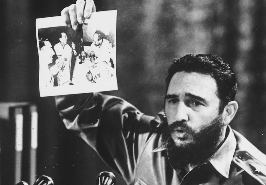5th July 1968: Cuban Prime Minister Fidel Castro, presents a photograph in which General Ovando Candia and other men of the Bolivian Army get drunk to celebrate the murder of Che Guevara, the Latin American revolutionary. (Photo by Keystone/Getty Images)