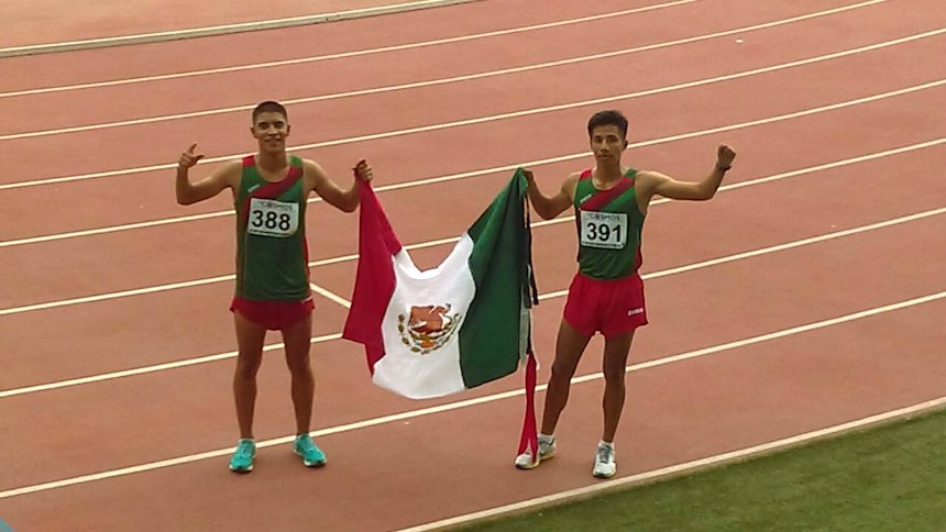 Atletas mexicanos con bandera de México 