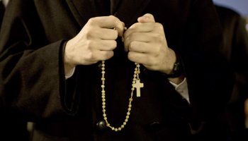 Sacerdote echándose el rosario