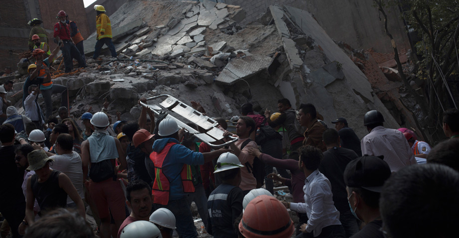 Un grupo de personas canta cielito lindo mientras recoge escombros tras el temblor de la CDMX