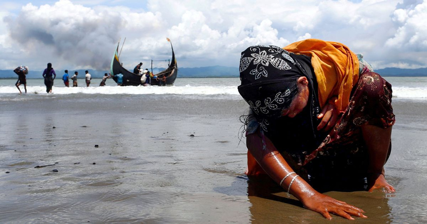 mujer refugiada rohingya agotada toca la orilla luego de cruzar la frontera entre Bangladesh 