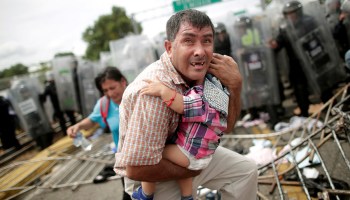 Migrante Hondureño protege a su hijo tras el enfrentamiento entre la Caravana Migrante y la Policia Federal en la frontera de Chiapas