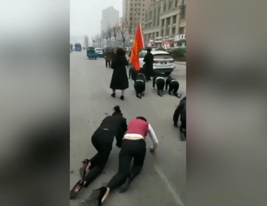 Empresa china obliga a sus empleados a gatear sobre el asfalto
