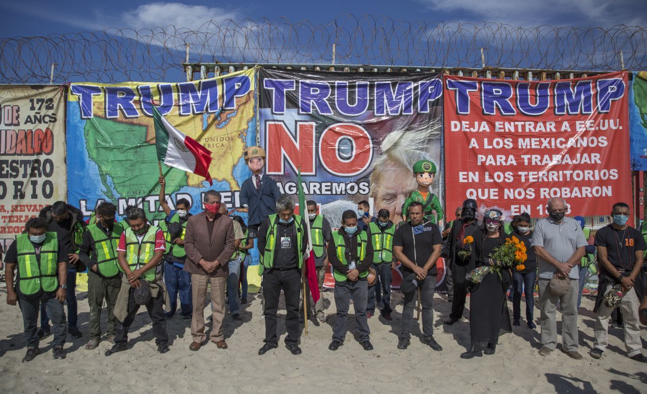 Migrantes queman piñata de Trump frente al muro fronterizo