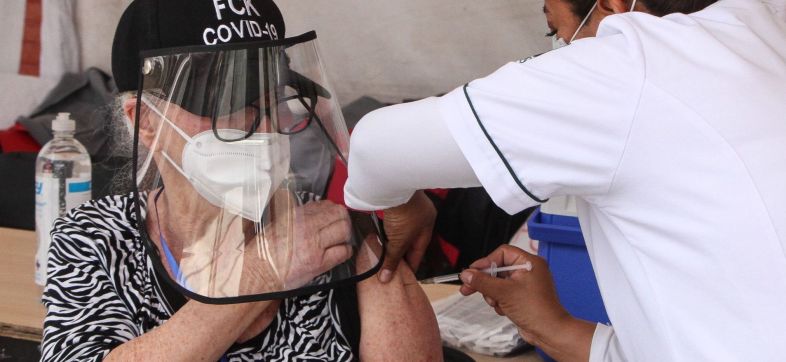 Mujer mayor recibe la vacuna contra el COVID