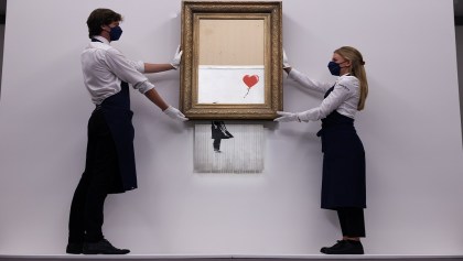 FILE PHOTO: A gallery assistant poses by 'Love is in the Bin', an artwork by Banksy, which will be for sale in an auction, at Sotheby's in London, Britain, September 3, 2021.