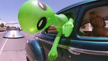 La foto de un extraterrestre inflable saliendo de un carro por la ventana
