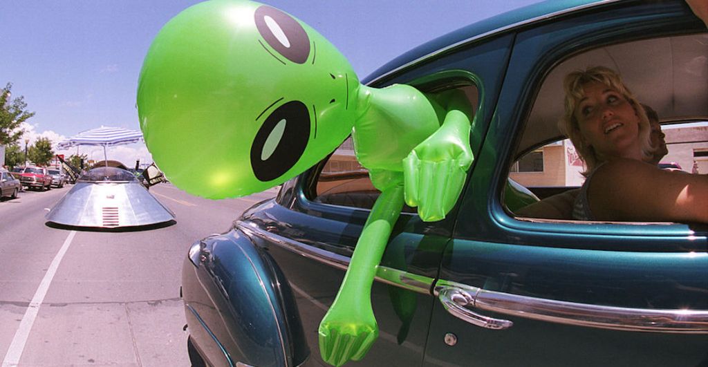 La foto de un extraterrestre inflable saliendo de un carro por la ventana