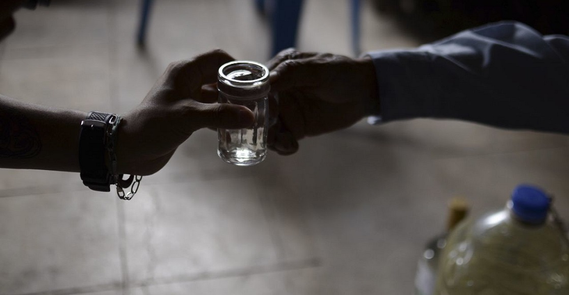 TIXTLA, GUERRERO, 29AGOSTO2016.- Ambrosio Muñiz Loranca, acompañado de su esposa María Luisa Ojeda, sirve una porción de mezcal añejado durante tres años de 48 grados 100% natural. Don Ambrosio resalta, "¡es un buen mezcal!". Para saberlo, se lo coloca en la muñeca de la mano, si el aroma desaparece muy rápido es adulterado y si éste permanece, es un buen mezcal.