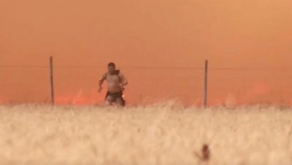 A man emerges from flames with burning clothes, as a wildfire burns in Tabara, Zamora Province, Spain, July 18, 2022 in this screen grab taken from a video.