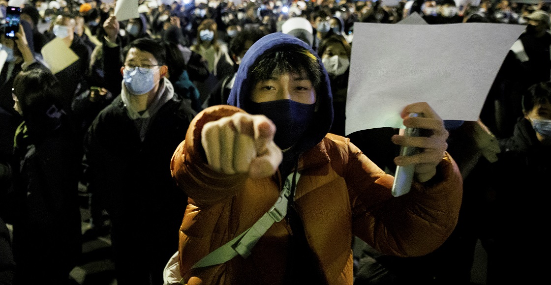 People hold white sheets of paper in protest over coronavirus disease (COVID-19) restrictions, after a vigil for the victims of a fire in Urumqi, as outbreaks of COVID-19 continue, in Beijing, China, November 27, 2022.