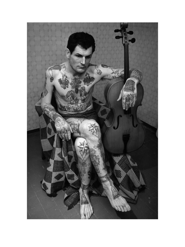 Hombre ruso con tatuajes que representan el complejo lenguaje del crimen y las prisiones 