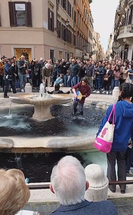 Activistas tiñen de negro el agua de una fuente en Roma en protesta por el cambio climático