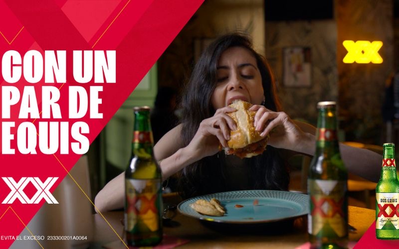 chica comiendo con cerveza Dos Equis