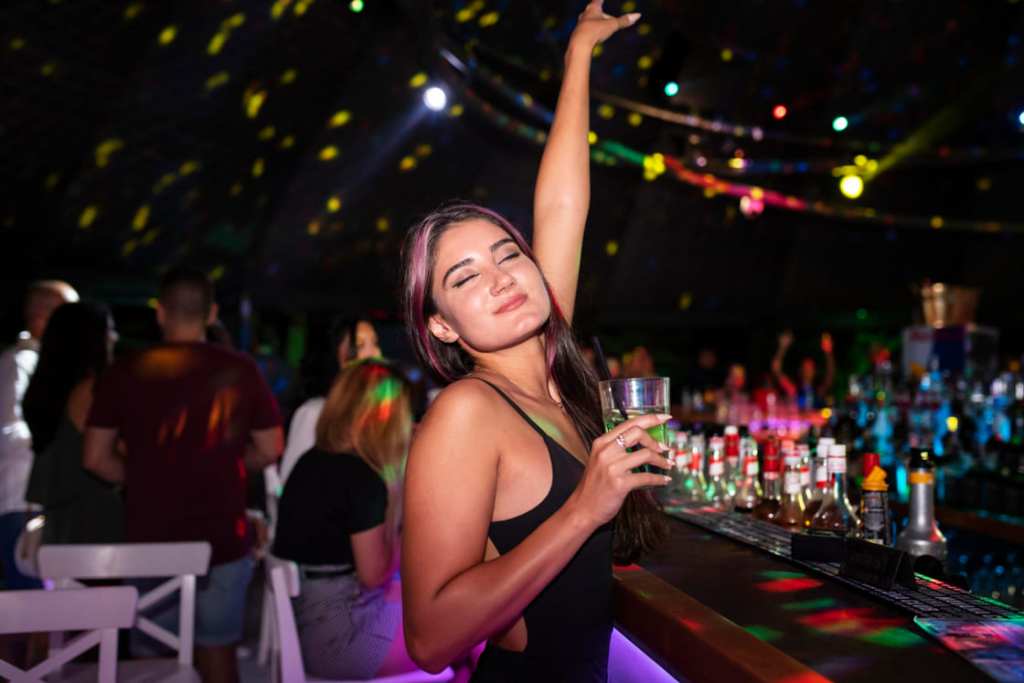 Mujer en fiesta bailando y bebiendo