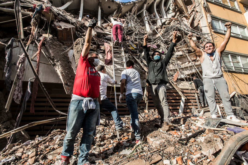 Rescatistas y voluntarios levantan el puño para pedir silencio en la zona
