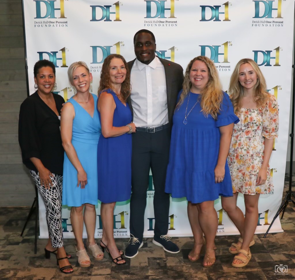 Derick Hall posa con asistentes en un evento de la Derick Hall One Percent Foundation.