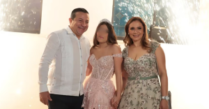 Juan Carlos Guerrero Rojas posa junto a una joven con vestido rosa y una mujer con vestido plateado durante una fiesta de XV años en Tabasco.