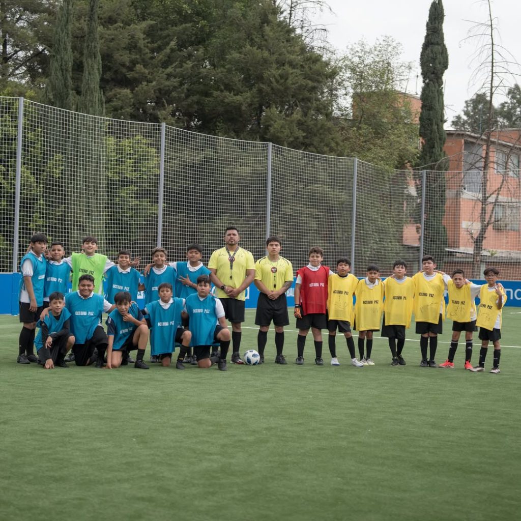 Niñas y niños posan en una cancha del programa FIFA Arena en México