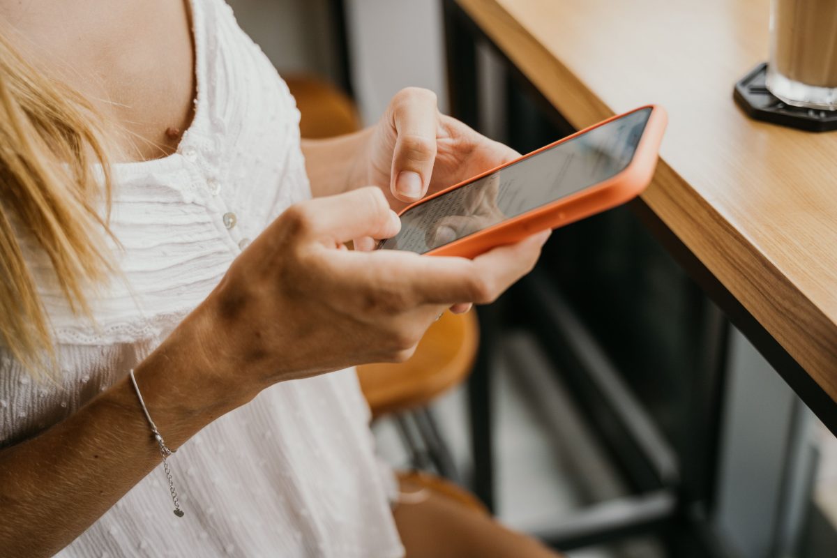 Persona utilizando un teléfono celular para navegar por internet.