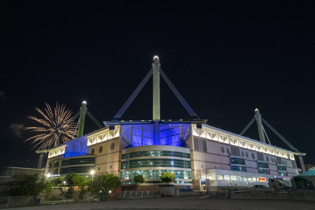 Vista exterior del Alamodome iluminado de noche, recinto clave para conciertos al buscar qué hacer en San Antonio, Texas.
