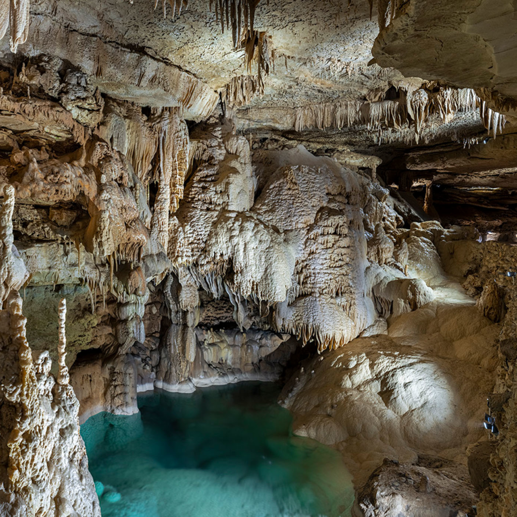 Lago subterráneo de aguas cristalinas dentro de las Natural Bridge Caverns, una increíble opción natural sobre qué hacer en San Antonio, Texas.