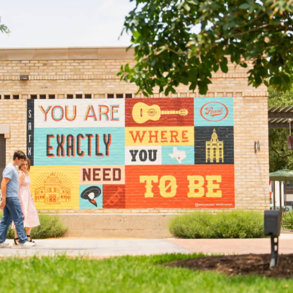 Mural colorido con la frase You are exactly where you need to be en el distrito Pearl, ilustrando qué hacer en San Antonio, Texas.