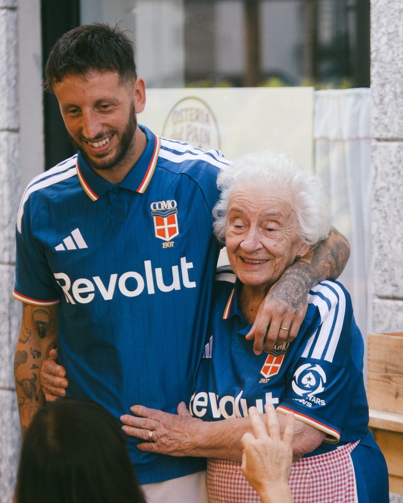 Una aficionada del Como 1907 posa la playera del club para la temporada 2026-27