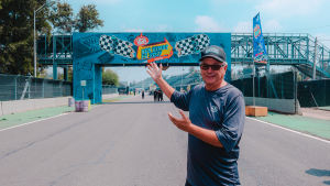 Kevin Lyman sonriendo y señalando el acceso principal del Vans Warped Tour México en el Autódromo Hermanos Rodríguez.