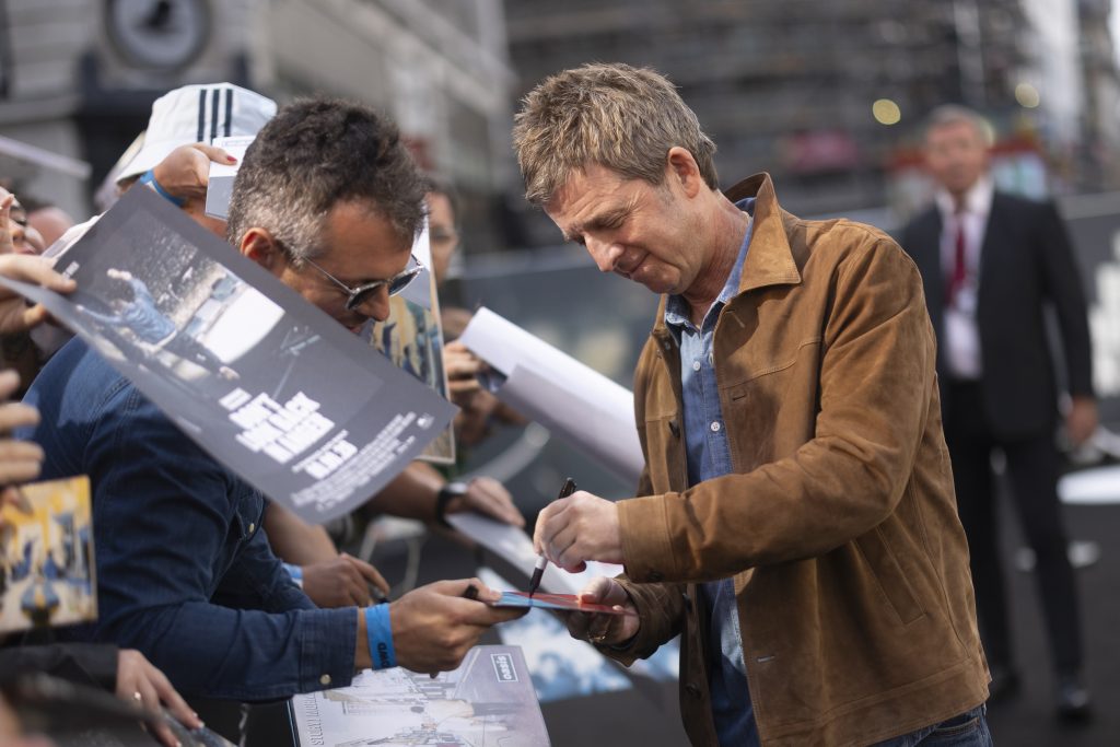 Fotografía de Noel Gallagher firmando autógrafos a los fans durante la premiere en el Reino Unido del documental 'Oasis: Don't Look Back in Anger'.