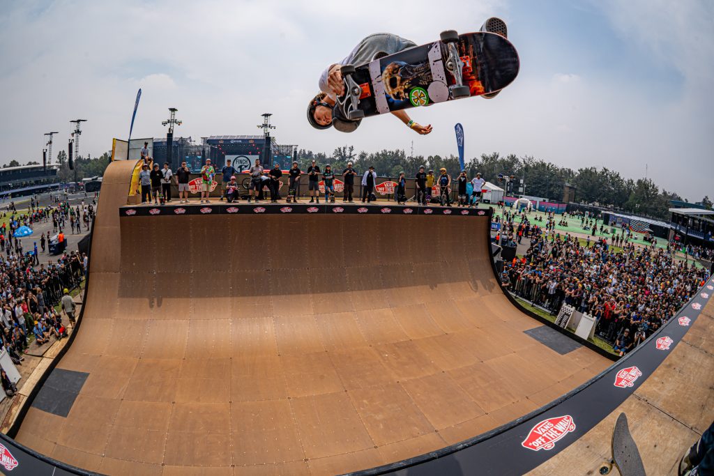 Skateboarder ejecutando un truco aéreo en la rampa de vert durante el Vans Warped Tour México 2026.
