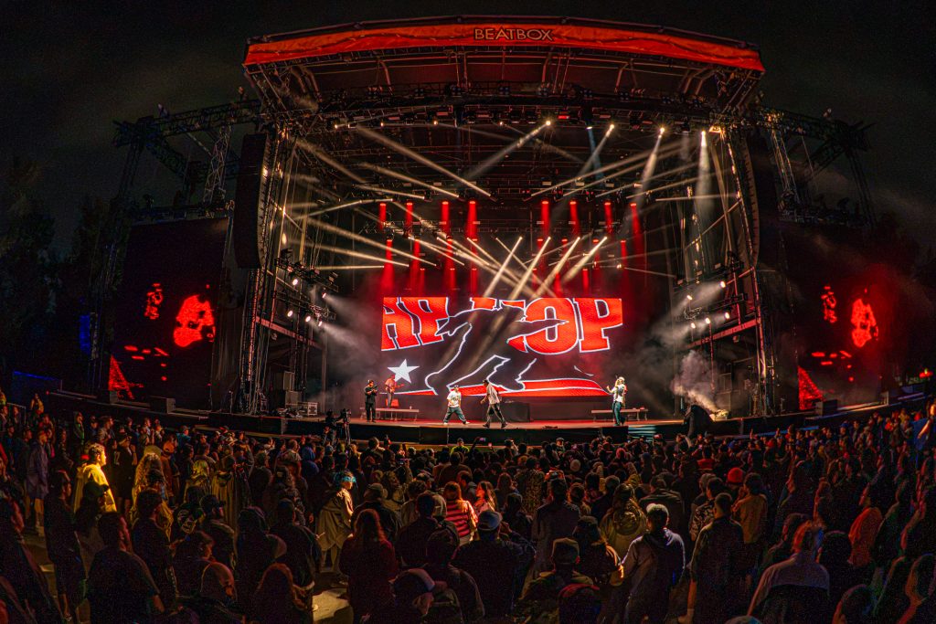 Vista general del escenario iluminado de rojo y la multitud durante el show de Kevis y Maykyy en el Vans Warped Tour CDMX 2026.